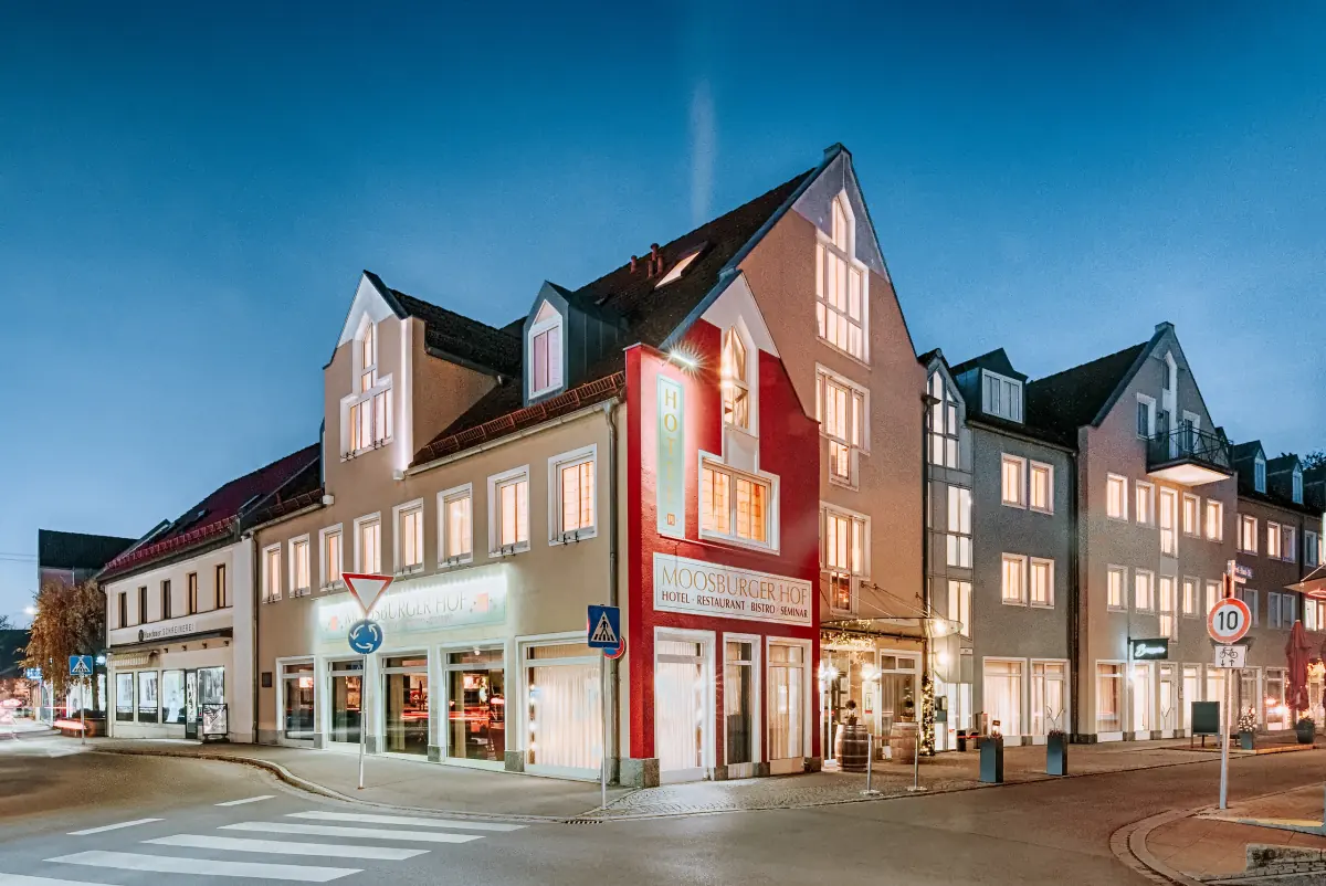 Stadthotel mit roter Giebelfassade zur blauen Stunde