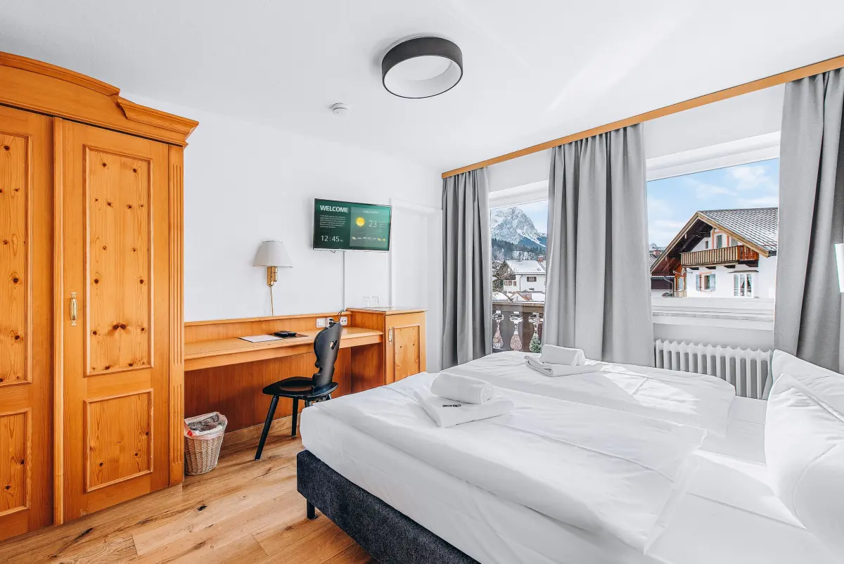 Bergzimmer mit Holzmöbeln und Blick auf Chalets